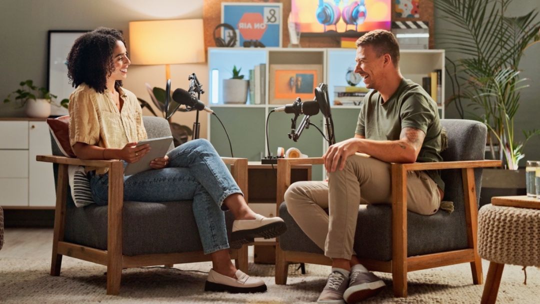 Podcast hosts recording in professional UK studio with quality microphones and equipment, illustrating podcast production costs and budgeting for 2026